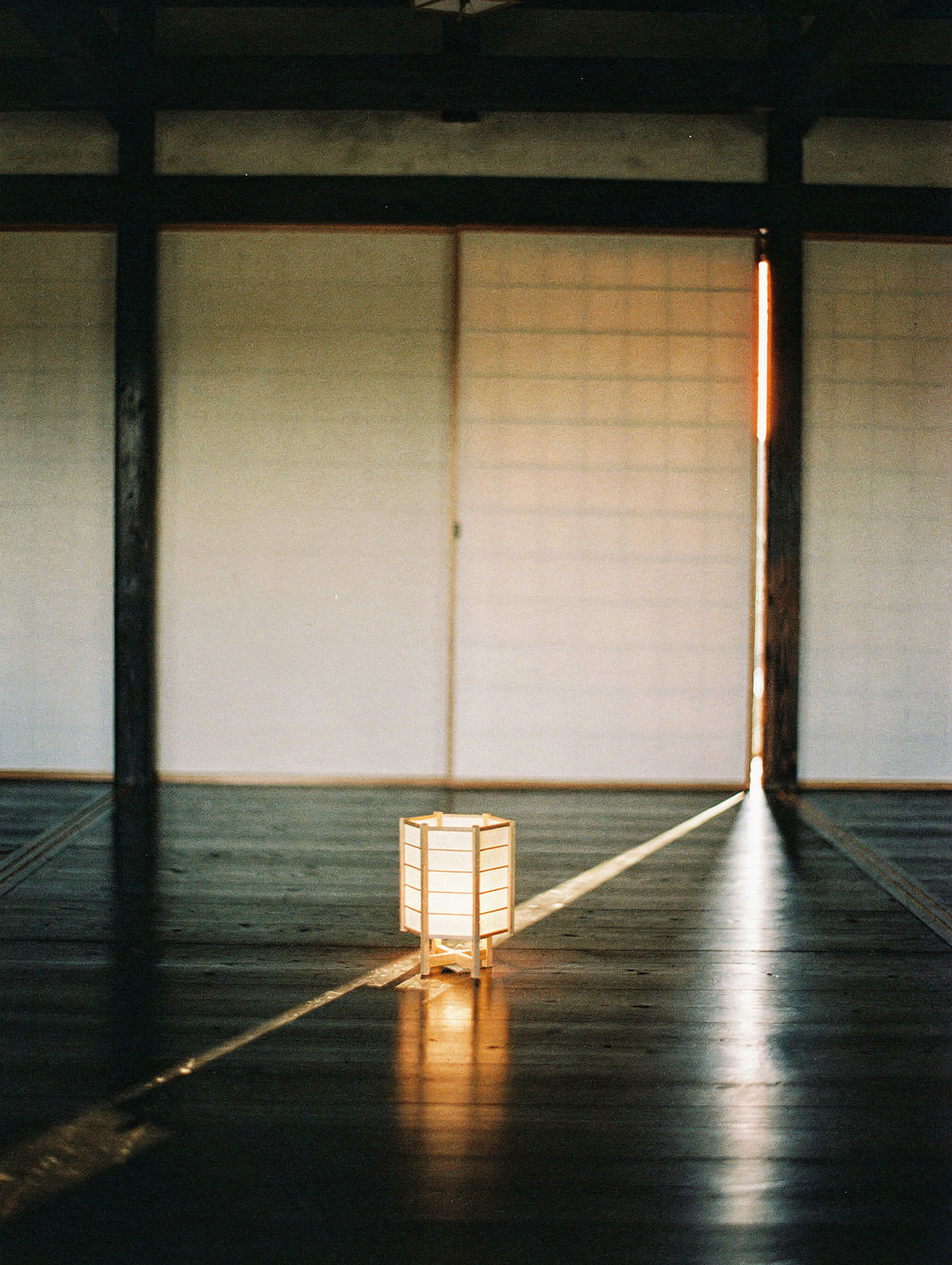 A paper andon lamp catching a thin slit of morning light.